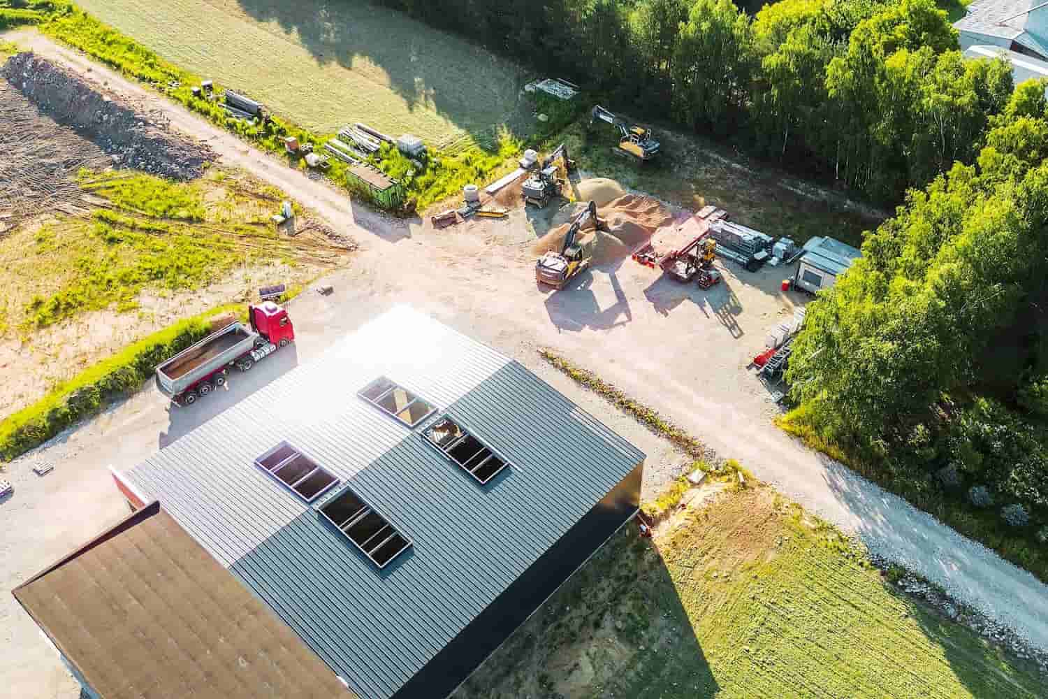 Aerial view of a Tasmanian construction site with heavy machinery and trucks in operation.